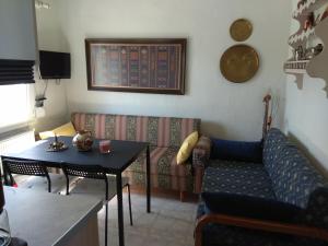 a living room with a couch and a table at Sofia's Cottage in Asprovalta
