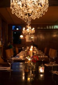 une grande table avec des verres à vin et un lustre dans l'établissement Herberg St. Brigida, à Noorbeek