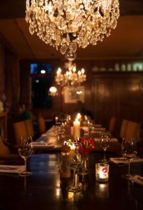 una mesa larga con copas de vino y una lámpara de araña en Herberg St. Brigida, en Noorbeek