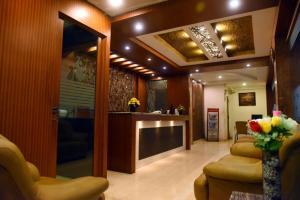 a lobby with a waiting room with couches and flowers at Samudra Residency in Chennai