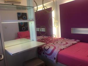 - une petite chambre avec un lit rose et une étagère dans l'établissement Apartemen Braga City Walk, à Bandung