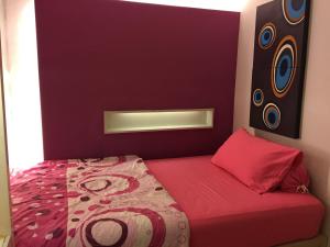 - une chambre avec un lit à tête rouge dans l'établissement Apartemen Braga City Walk, à Bandung