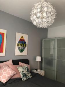 1 dormitorio con cama y lámpara de araña en Apartament Garnizon No. 1 en Gdansk