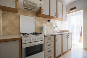 a kitchen with a white stove and a sink at Apartament z 3 sypialniami - bezpłatny parking in Łódź