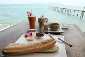a table with a plate of bread and a drink at Enjoy Beach in Bophut