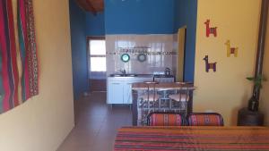 a kitchen with blue walls and a table and chairs at Casa en Cafayate in Cafayate