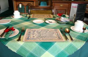 a table with a blue and green table cloth with silverware at Greenlawns in Nairn