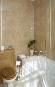 a bathroom with a toilet and a bath tub and a toilet at Greenlawns in Nairn