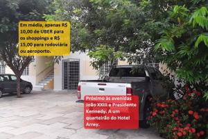 a car parked in front of a building with a sign at Flats Condominio Professor Wilson in Teresina