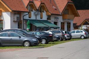 une rangée de voitures garées devant un bâtiment dans l'établissement Apartma Jelenček, à Moravske Toplice