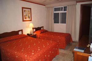 a hotel room with two beds and a window at Hotel Veracruz in Oaxaca City