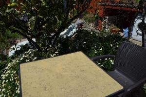un tavolo e una panchina in un giardino fiorito di Rural Gomera ad Arure