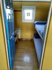 a room with two bunk beds and a window at Albergue De Peregrinos Santiago Apostol in Puente la Reina