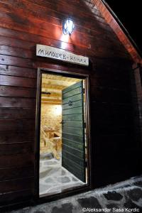 a wooden building with a door and a sign on it at Komovi Eko Katun Martinovica 1750 in Kolašin