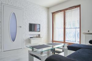 een woonkamer met een glazen tafel en een bank bij D&A Apartments Old Town in Krakau