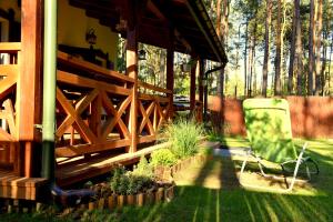 patio z zielonym krzesłem siedzącym w trawie w obiekcie 66 Szyszek w mieście Susiec