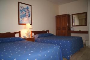 a hotel room with two beds and a mirror at Hotel Veracruz in Oaxaca City +12 photos