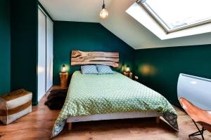 - une chambre avec un lit aux murs verts et une lucarne dans l'établissement Le Ch'ti Champenois, à Épernay