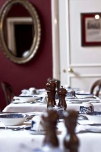 a long table with white plates and a mirror at Jeakes House in Rye