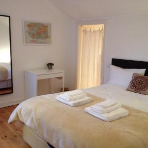 ein Schlafzimmer mit einem Bett mit Handtüchern darauf in der Unterkunft Campo de Ourique Premium in Lissabon