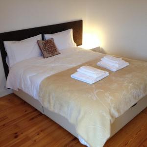 ein Bett mit zwei Stapeln Handtüchern drauf in der Unterkunft Campo de Ourique Premium in Lissabon