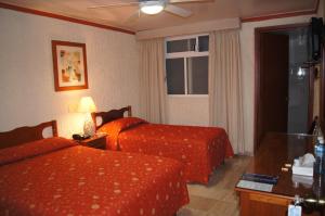 a hotel room with two beds and a window at Hotel Veracruz in Oaxaca City