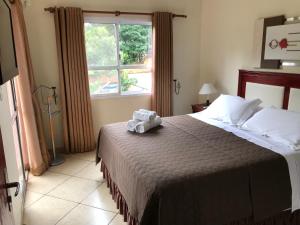 ein Schlafzimmer mit einem Bett, auf dem ein Teddybär liegt in der Unterkunft Ocio Apart in Puerto Iguazú