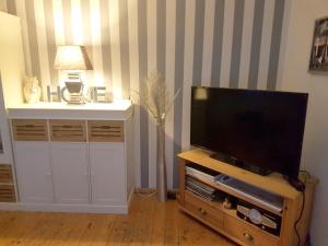 ein Wohnzimmer mit einem Flachbild-TV auf einem Holzständer in der Unterkunft Ferienwohnung Kensche in Arnstadt