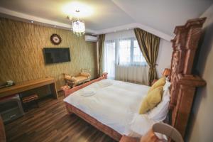 a bedroom with a large bed and a living room at Studio B in Buftea