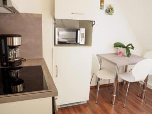 una piccola cucina con un tavolo e un microonde di Haus am Fluss a Baiersbronn
