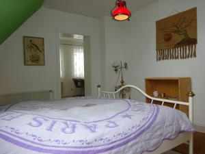 a bedroom with a bed with a purple and white comforter at Ostseenähe Homestay in Gadebusch