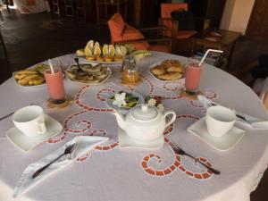 a table with a white table cloth with food on it at Le Zahir Lodge in Ambatoloaka