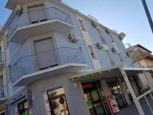 a white building with balconies on the side of it at Hotel I Pini in Lido di Pomposa