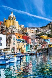 a group of boats in a body of water with buildings at San Michele in Procida