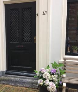 a black door with a bunch of flowers in front at Klein Loenen in Loenen aan de Vecht