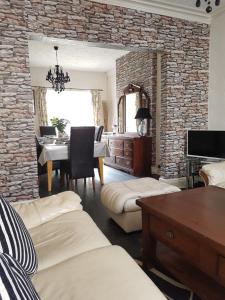 a living room with a table and a stone wall at Llandudno holiday home in Llandudno