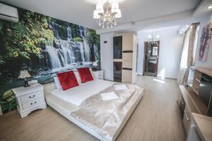 a bedroom with a bed with a waterfall mural on the wall at Studio B in Buftea