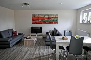 ein Wohnzimmer mit einem Sofa und einem Tisch in der Unterkunft Ferienwohnung Westend in Kappel-Grafenhausen