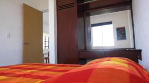 um quarto com uma cama com um cobertor colorido em Relaxing Puertomorelos em Puerto Morelos