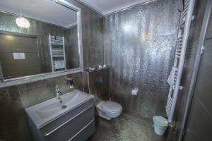 a bathroom with a sink and a toilet and a mirror at Studio B in Buftea