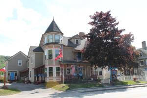 a large house with two flags in front of it at Strictly Moose Luxury Vacation Suites in Gorham