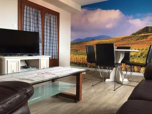 Gite Fruehmess في إتيرسويلير: غرفة معيشة مع تلفزيون وطاولة مع كراسي
