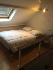 un lit dans une petite pièce avec une fenêtre dans l'établissement Villa Coquelicot Industriel, au Tréport