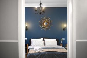 a blue bedroom with a bed with a chandelier at Sunburst Apartment in Tbilisi City