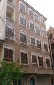 an old brick building with white windows on a street at Om Pension Guest House in Pātan