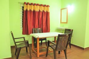 a dining room with a table and four chairs at Jayaram Residency Srikalahasti in Srikalahasti