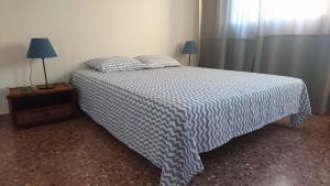 バレンシアにあるPrecioso piso junto al antiguo barrio de Campanarのベッドルーム1室(青と白の毛布付きのベッド1台付)