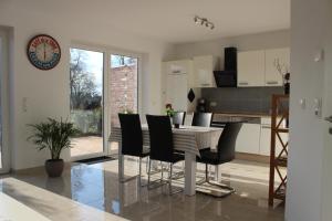 a kitchen and dining room with a table and chairs at Ferienhaus Westwind in Rhauderfehn