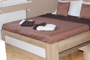 a wooden bed with two towels on top of it at Apartment Cherry in Zrenjanin