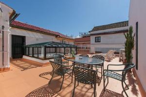 eine Terrasse mit Stühlen und einem Tisch auf dem Balkon in der Unterkunft Casa de Tintes in Sevilla